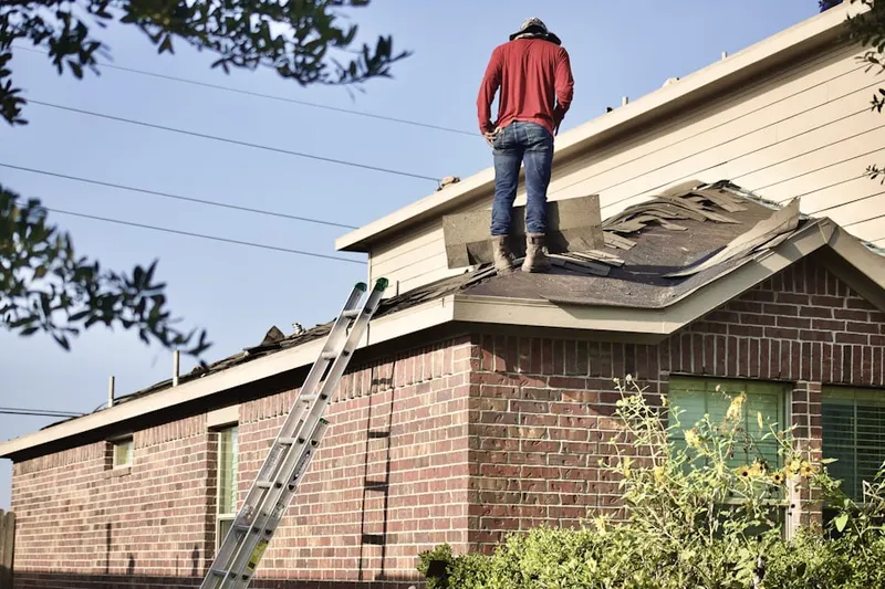 Professional roofer working on a residential roof in Colbert
